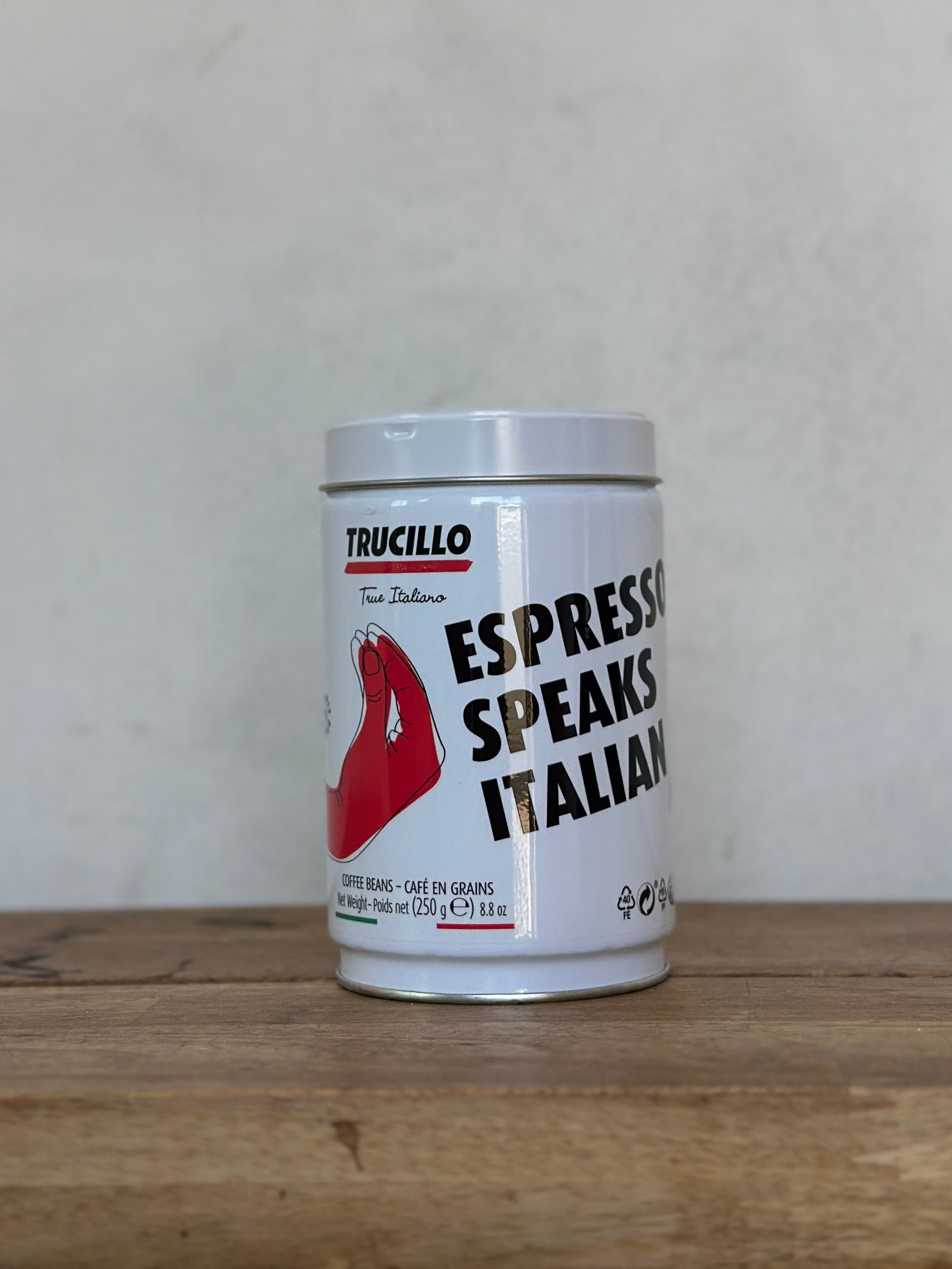 Canister of Trucillo Espresso Speaks Italian on a wooden surface with a light gray background