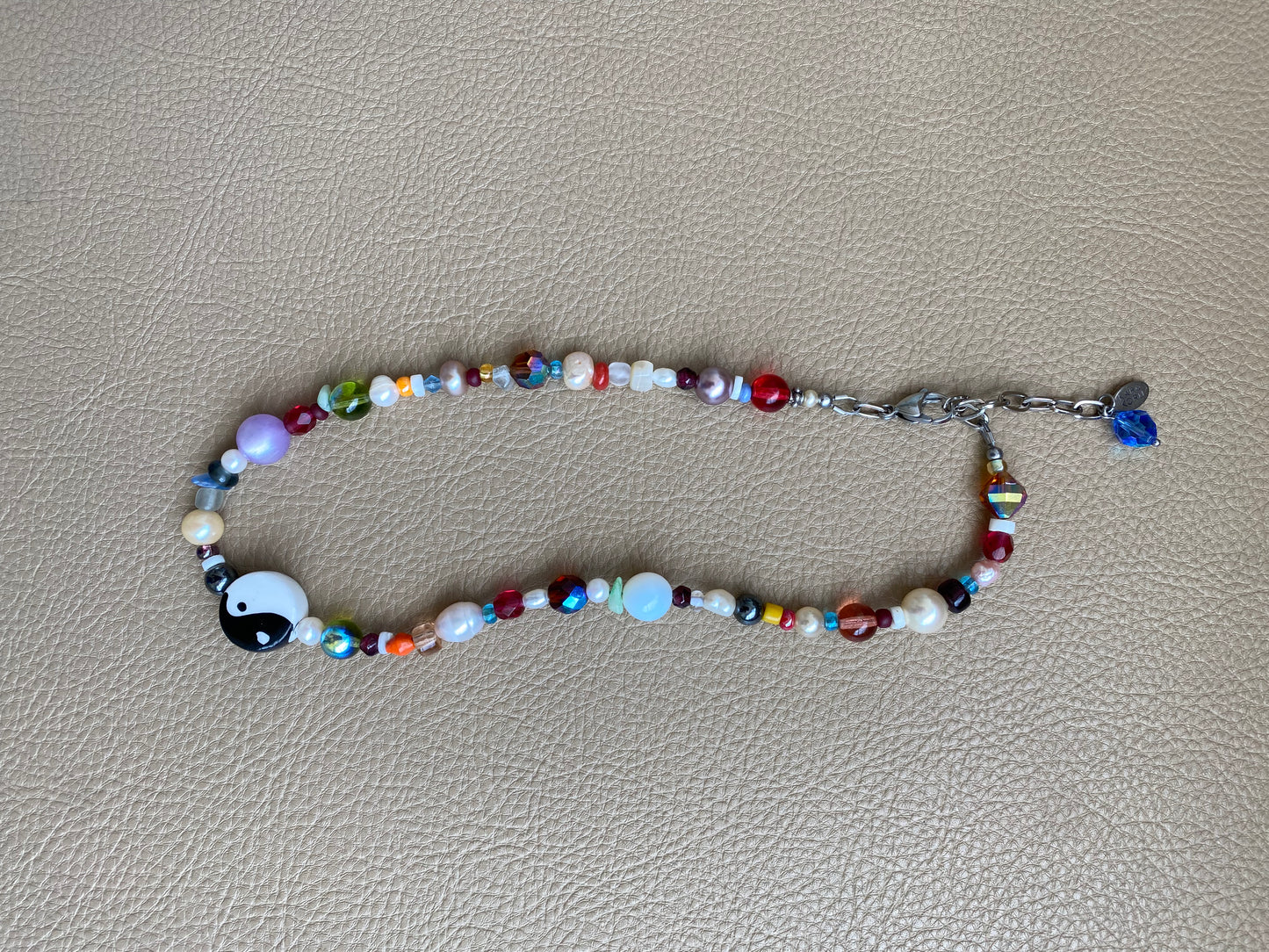 multi-color beaded necklace with a chunky yin-yang charm as the focal piece of the necklace