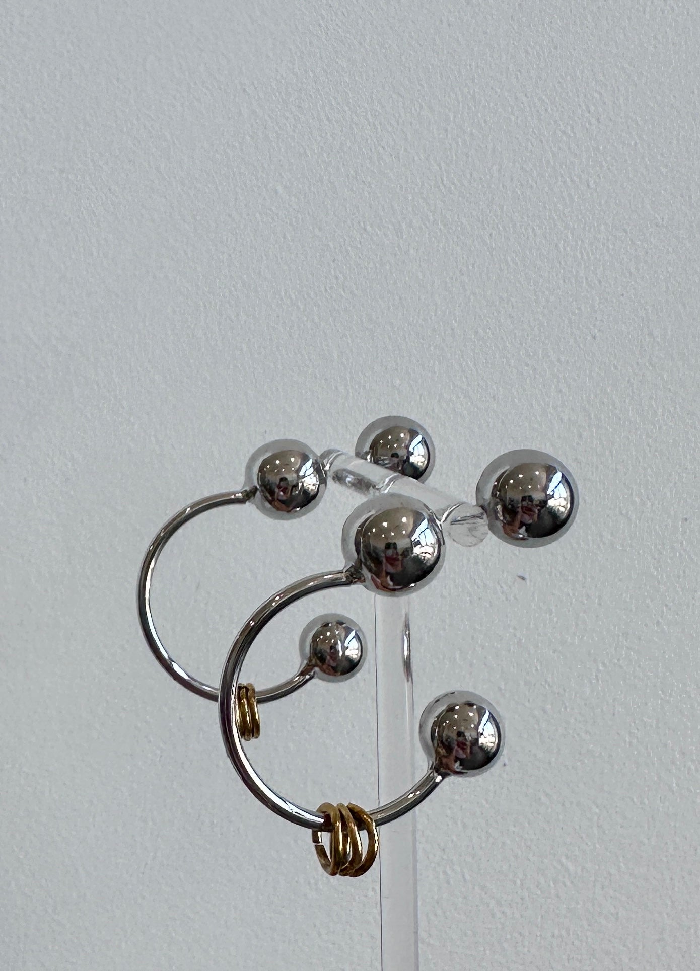 Metal pierced earring with brass detail