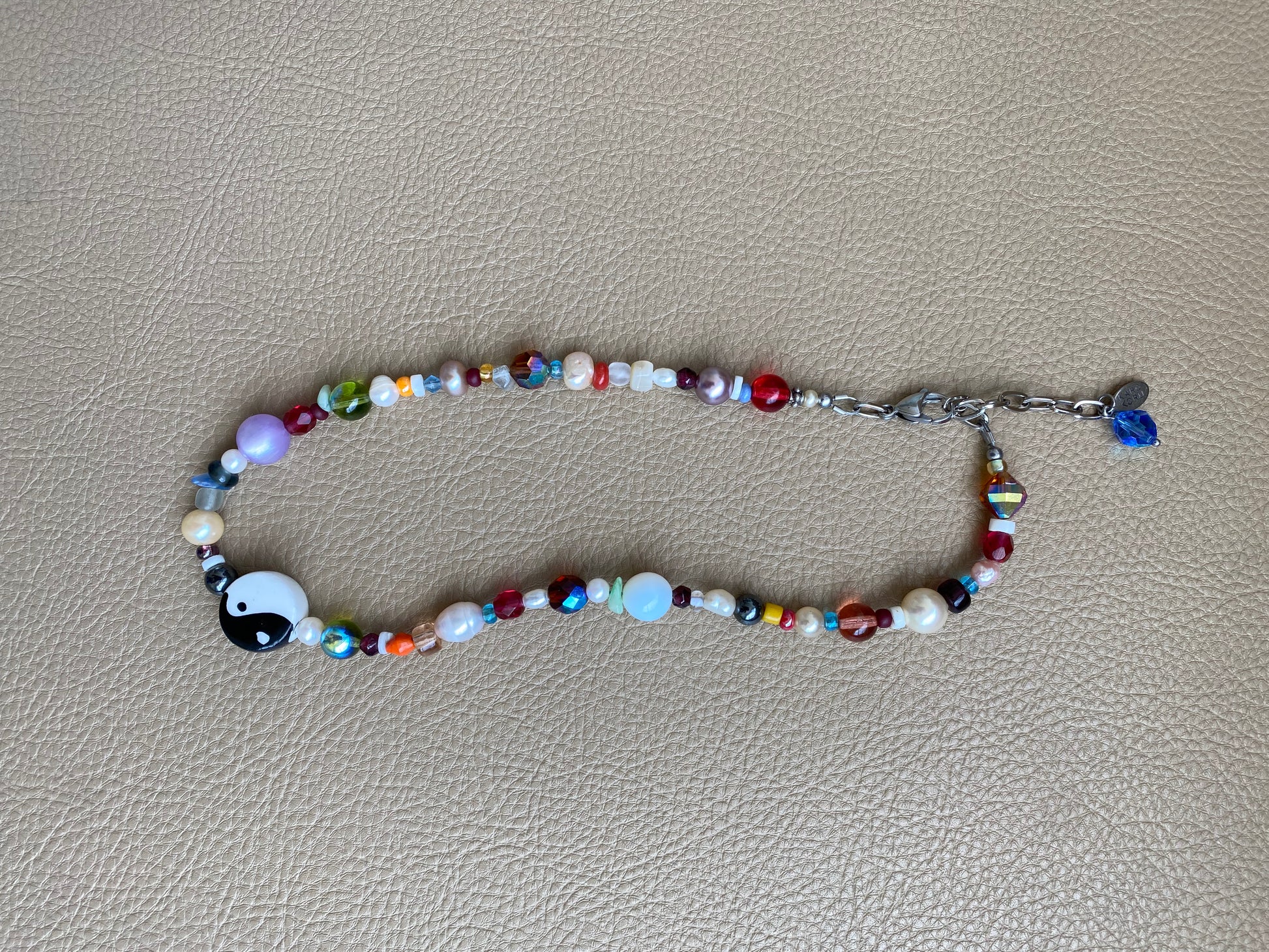 multi-color beaded necklace with a chunky yin-yang charm as the focal piece of the necklace