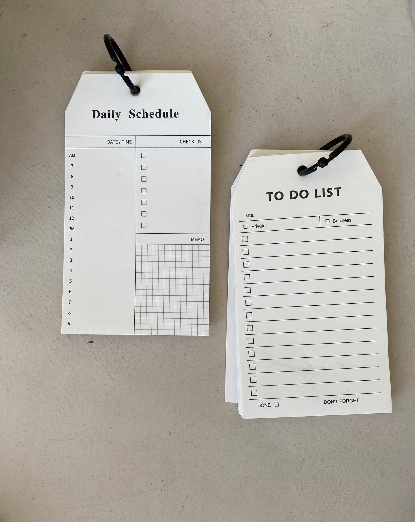 Daily Schedule notepad and To Do List notepad - luggage tag shaped cream colored paper - each notepad is held together with a black plastic binder ring 